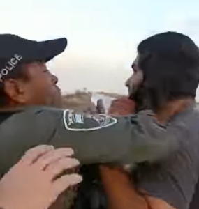 שוטר מג"ב מושך בפאה של מתיישב